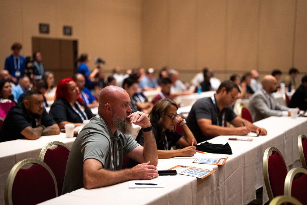A Crowd in a lecture learning and taking notes