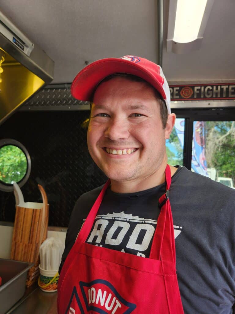 Picture of man in red apron smiling