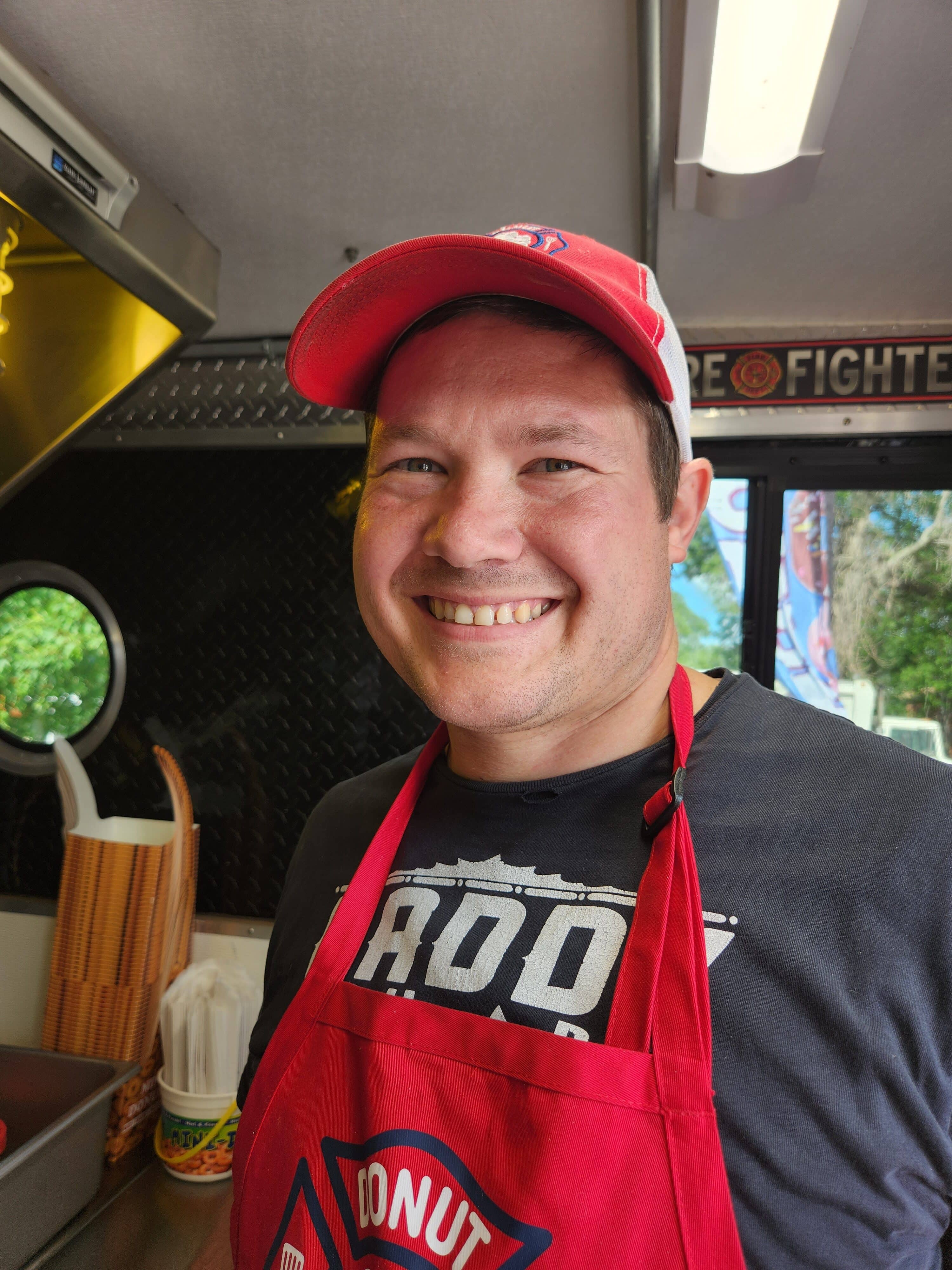 Picture of man in red apron smiling
