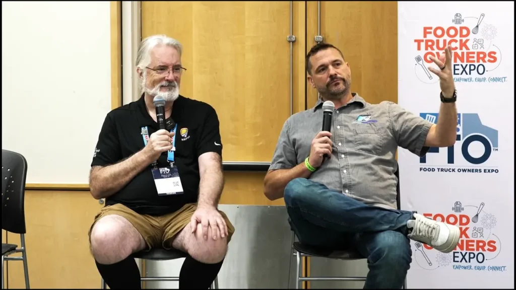 2 Men on Stage talking into microphones at the FTO Expo